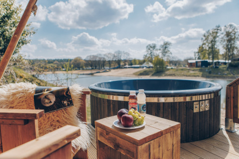 Uitzicht op bubbelbad, fruit en dranken op houten tafel bij Glamfield Lodge Premium, Wilsumer Berge, Duitsland.