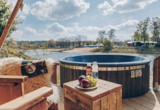 Uitzicht op bubbelbad, fruit en dranken op houten tafel bij Glamfield Lodge Premium, Wilsumer Berge, Duitsland.