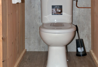 Toilette im Safari-Zelt auf Campingplatz de Krabbeplaat in den Niederlanden mit Holzboden und Trennwänden.