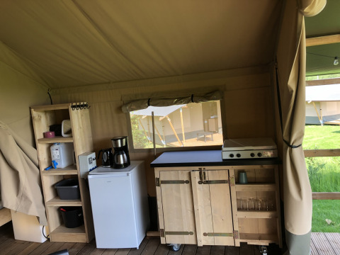 Keukenhoek in een safaritent met fornuis, koelkast en planken bij Camping de Regenboog, Tsjechië.