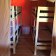 Interno di una tenda safari con due letti a castello in legno, arredi essenziali e pavimento in legno.