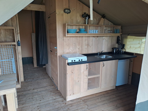 Indretning af et safari telt med køkken og træmøbler på Camping de Zeven Heuveltjes i Holland.