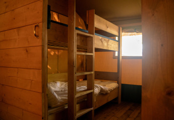 Interior view of a safari tent with bunk beds and wooden walls at Campsite de Zeven Heuveltjes in the Netherlands.