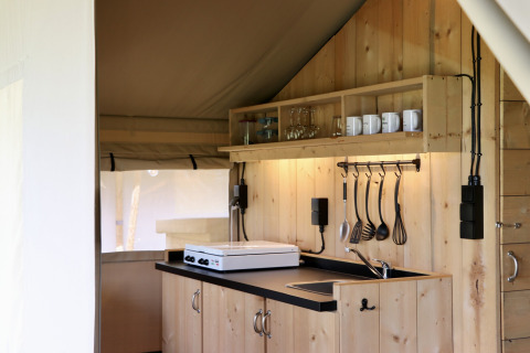 Vista de la cocina pequeña en una tienda safari en el Camping de Heerlijkheid Vorenseinde, Países Bajos.