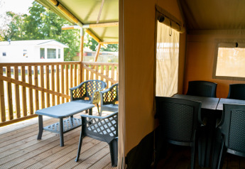 Tienda tipo safari con terraza y zona de estar en el camping Tussen de Diepen en los Países Bajos.