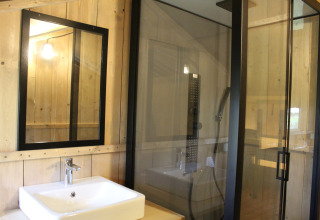 Baño en la tienda Safari tent + sanitary, Family park Goolderheide, Bélgica, con espejo y ducha moderna.