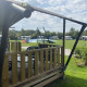 View from a safari tent with porch at Campsite Dal van de Mosbeek, Netherlands, with caravans and playground.