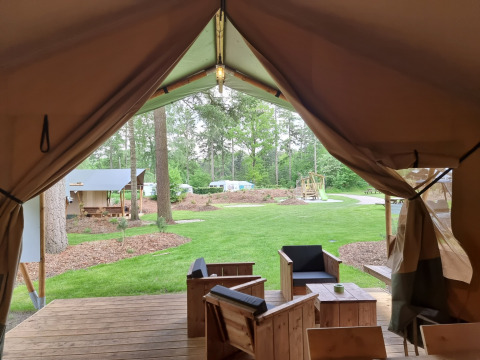 Vue depuis l’entrée d’une tente safari au camping Bockenauer Schweiz, Allemagne, avec mobilier en bois.