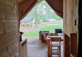 View from inside a safari tent with wooden floor and deck at Campsite Bockenauer Schweiz in Germany.