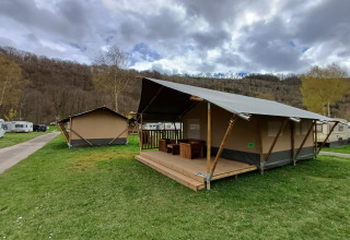 Safari-Zelt auf dem Campingplatz la Roche in Belgien mit Holzterrasse und malerischer Landschaft.