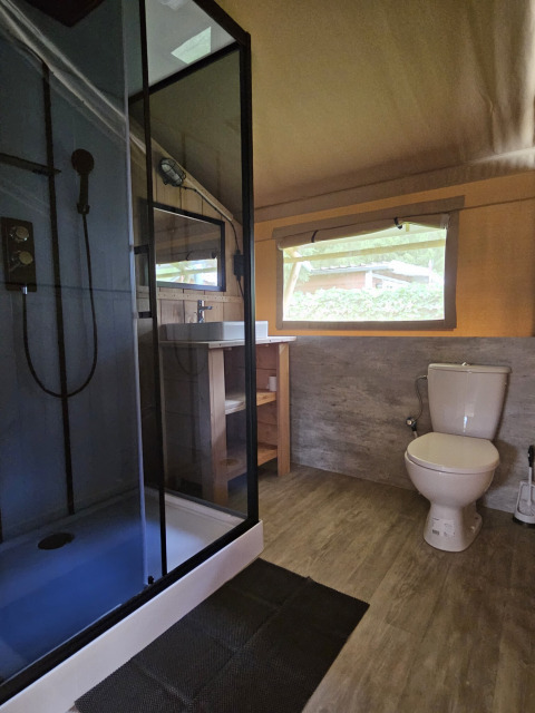 Modernes Badezimmer im Safarizelt mit Dusche, WC und Fenster auf Campingplatz Vallee de L'Our, Luxemburg.