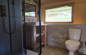 Salle de bain de tente safari avec douche, WC et fenêtre au Camping Vallee de L'Our, Luxembourg.