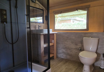 Salle de bain de tente safari avec douche, WC et fenêtre au Camping Vallee de L'Our, Luxembourg.