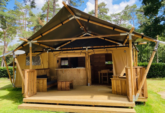 Tente safari pour 6 personnes avec sanitaires au bord du lac, située sur un camping verdoyant et boisé.