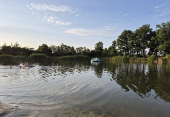 Børn leger i en sø med oppustelig legetøj ved en safaritelt-campingplads i Holland.