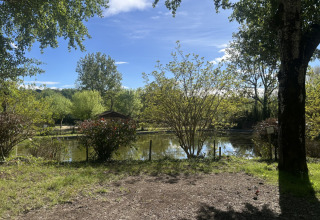 Mooi zicht op een rustige vijver omgeven door bomen in vakantiedomein Les Rives de Courtes, Occitanie, Frankrijk.