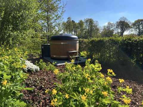 Holzfasser-Whirlpool im Garten neben dem Tiny House Anthropod im Ferienpark 't Rheezerwold, Niederlande.