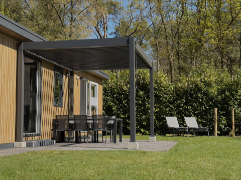 Outdoor area of Forest Lodge at Family Holiday Park Krieghuusbelten, Netherlands, with patio and loungers.