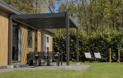 Area esterna del Forest Lodge al Family Holiday Park Krieghuusbelten, nei Paesi Bassi, con patio.