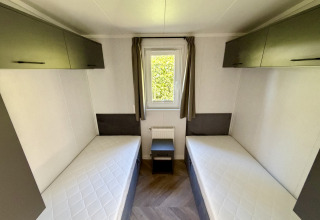 Habitación con dos camas individuales y armarios en Forest Lodge del parque familiar Krieghuusbelten.