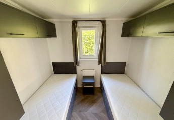 Habitación con dos camas individuales y armarios en Forest Lodge del parque familiar Krieghuusbelten.