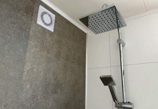 Doccia moderna con grande soffione e ventilazione a parete in Forest Lodge, Krieghuusbelten, Paesi Bassi.