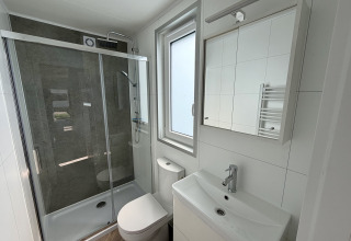 Petite salle de bain moderne avec douche, toilettes et lavabo dans un tiny house au Krieghuusbelten, Pays-Bas.