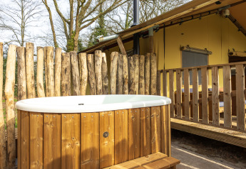 Bain à remous en bois avec marches devant la tente safari «De Bos Escape» à Gooise Heide, Pays-Bas.