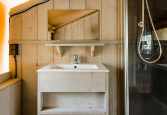 Badezimmer im Safarizelt De Stille Heide mit Waschbecken, Spiegel und Dusche, Gooise Heide, Niederlande.