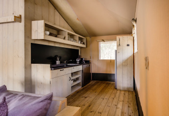 Innenaufnahme eines Safarizelts in De Stille Heide, Gooise Heide, Niederlande, mit Holzboden und Küche.