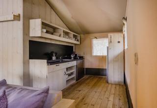 Interiør af et safari telt i De Stille Heide på Gooise Heide, Holland, med trægulv og køkken.