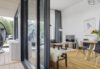 Modern living room and terrace with hanging chair at Boslodge Plus with hot tub, Holiday center 't Schuttenbelt, Netherlands