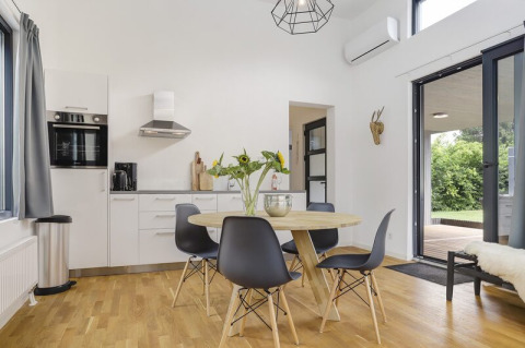 Modern kitchen and dining area in Boslodge Plus at 't Schuttenbelt, featuring garden views and patio.