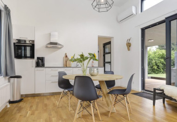 Modern kitchen and dining area in Boslodge Plus at 't Schuttenbelt, featuring garden views and patio.