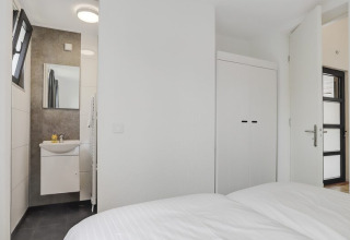 Bedroom featuring en-suite bathroom, built-in closet, and modern decor at Boslodge Plus met Hottub lodge.