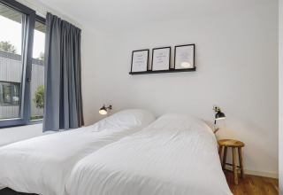 Chambre moderne au Boslodge Plus met Hottub, centre de vacances 't Schuttenbelt aux Pays-Bas, lits jumeaux blancs.
