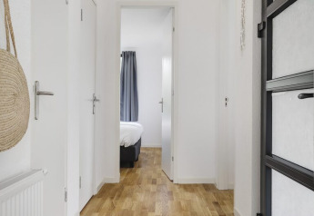 Heller Flur mit Holzboden im Boslodge Plus bei 't Schuttenbelt, mit Blick ins Schlafzimmer, Niederlande.