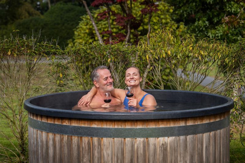Par nyder et glas vin i en udendørs hottub ved Boslodge Plus met Hottub, Holiday center 't Schuttenbelt, Holland.