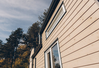 Nærbillede af ‘Koya’ Tiny Loft ved Wilsumer Berge, Tyskland, med træbeklædning og store vinduer.