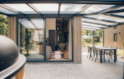 Moderne tiny house Rosendael met overdekt terras en tuinmeubilair in Veluwe park de Bosgraaf, Nederland.