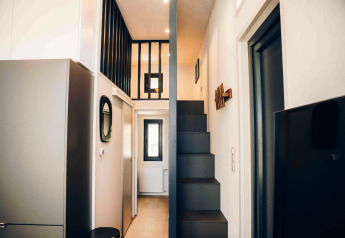 Innenraum eines modernen Tiny Houses mit Treppe, Galerie und Fenstern im Veluwe Park de Bosgraaf, Niederlande.
