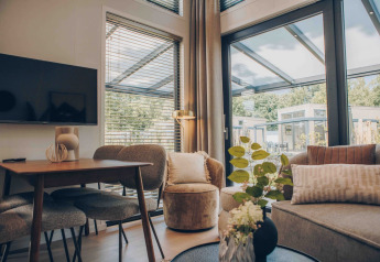 Moderne woonkamer in tiny house Rosendael met hottub op Veluwe park de Bosgraaf, Nederland, met grote ramen.