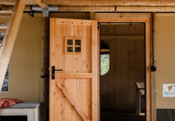 Entrance of safari tent De Bosvilla at Gooise Heide in the Netherlands with open wooden doors.