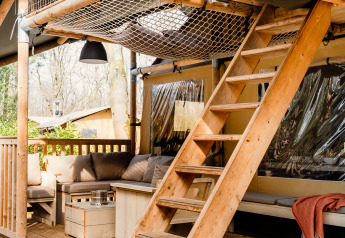 Wooden stairs and terrace at a luxury safari tent named De Bosvilla at Gooise Heide in the Netherlands.