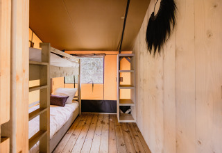 Interieur van safaritent De Bosvilla op Gooise Heide, Nederland met stapelbed en houten vloer.