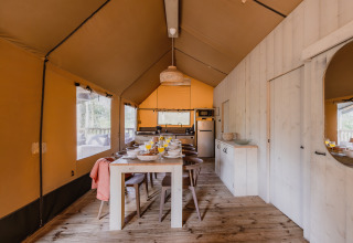 Interieur van safaritent ‘De Bosvilla’ op Gooise Heide in Nederland met eettafel en keukenruimte.