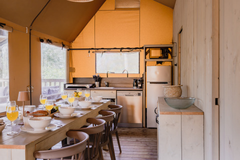 Gezellige keuken en eethoek in safaritent De Bosvilla op de Gooise Heide, Nederland, gedekt voor ontbijt.