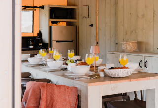 Ontbijttafel met sap in safaritent ‘De Bosvilla’ op Gooise Heide in Nederland, uitnodigend gedekt.