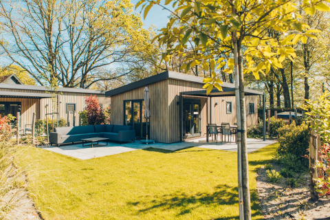 Moderno lodge Loevestein Comfort con vasca idromassaggio, terrazza spaziosa e giardino verde e soleggiato.