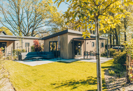 Lodge Loevestein Comfort moderne avec bain à remous, grande terrasse et jardin verdoyant par beau temps.